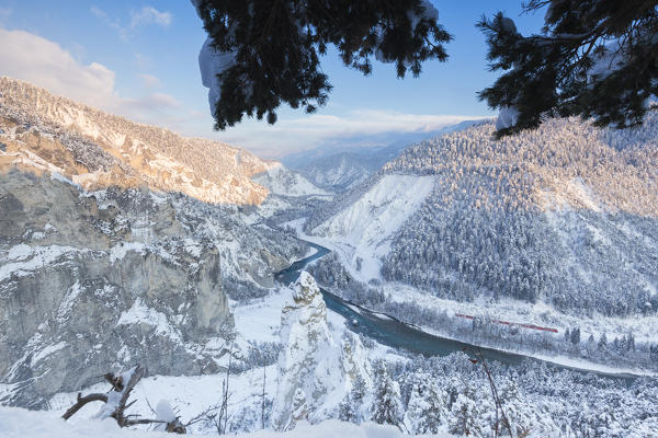 Transit of the Red Train in the deep Rhine Gorge. Rhein Gorge(Ruinaulta), Flims, Imboden, Graubunden, Switzerland, Europe