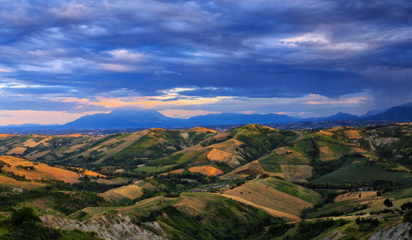 Hills overlooking  Majella group illuminated by the sun at sunset. Calanchi of Atri, Abruzzo, Italy.