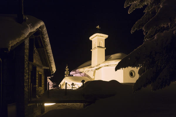 Church of Berisal illuminated during a winter night. Berisal, Canton of  Valais/Wallis, Switzerland.