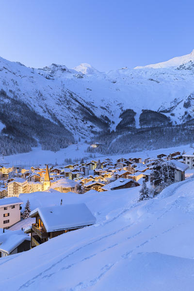 Lights on the church and the historic center of Saas Fee during twilight. Saas Fee, Canton of Valais / Wallis, Switzerland.