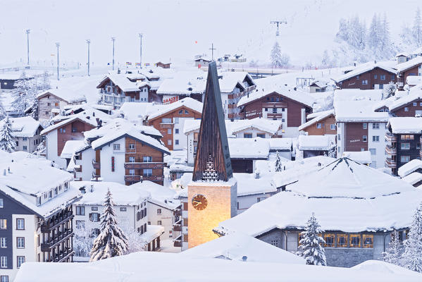 Illuminated bell tower of the church of Saas Fee after a snowfall. Saas Fee, Canton of Valais / Wallis, Switzerland.