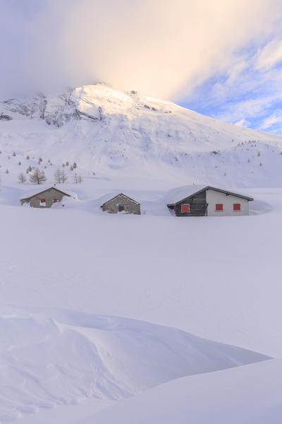 Huts after heavy snowfall with the summit of Hübschhorn in the background. Simplon Pass, Canton of  Valais/Wallis, Switzerland.