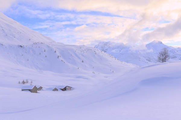 Huts partly submerged by a heavy snowfall to the Simplon Pass during  sunset. Simplon Pass, Canton of  Valais/Wallis, Switzerland.