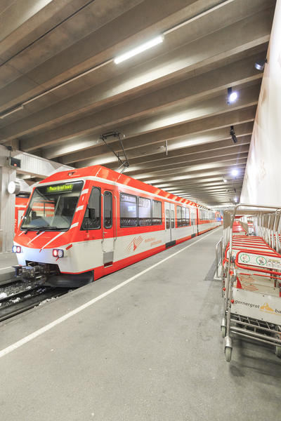Train waiting to leave and luggage trolleys at Zermatt railway station, Canton of Valais / Wallis, Switzerland.