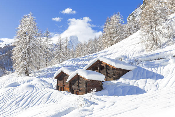 Traditional Zmutt huts after a heavy snowfall with the Matterhorn hidden by clouds. Zermatt, Canton of Valais / Wallis, Switzerland.