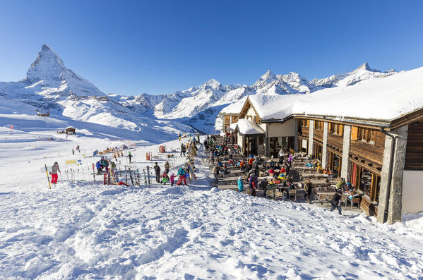 Restaurant on the ski slopes full of customers with Matterhorn in the background. Riffelberg, Zermatt, Canton of Valais / Wallis, Switzerland.