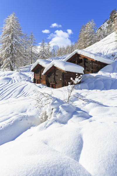 Traditional Zmutt huts after a heavy snowfall with the Matterhorn hidden by clouds. Zermatt, Canton of Valais / Wallis, Switzerland.