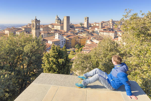 Tourist observes the skyline of the Upper Town of Bergamo, Lombardy, Italy.
