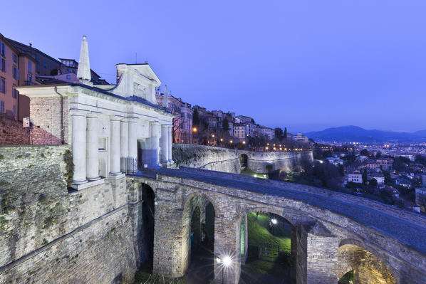Stone bridge to the Porta San Giacomo in Upper Town (Città Alta) at dusk. Bergamo, Lombardy, Italy.