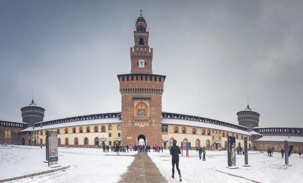 A runner run in the courtyard of Sforza Castle after a snowfall. Milan, Lombardy, Northern Italy, Italy.