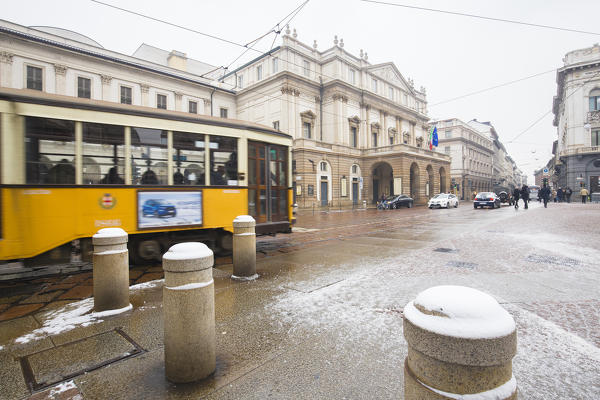 Transit of a traditional tram in front of Scala Theater. Milan, Lombardy, Northern Italy, Italy.