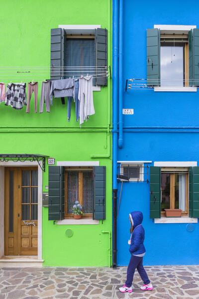 Child walks across colorful houses of Burano island, Venice, Veneto, Italy, Europe (MR)