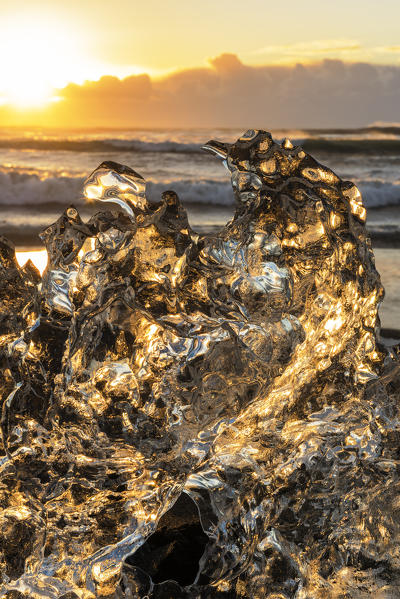 Jokulsarlon glacier lagoon, Iceland. Sunlight reflections over a small black of ice on the shore.