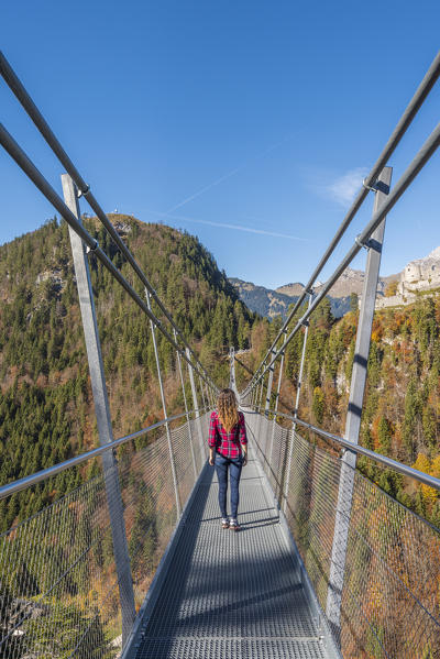 Reutte, Tyrol, Austria, Europe. Ehrenberg Castle and the Highline 179, the world’s longest pedestrian suspension bridge. A young woman cross the bridge