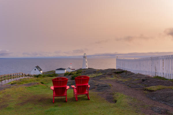 Cape Spear Lighthouse with two red wooden dechchair, occupies the most eastern point in North America, Newfoundland, Canada