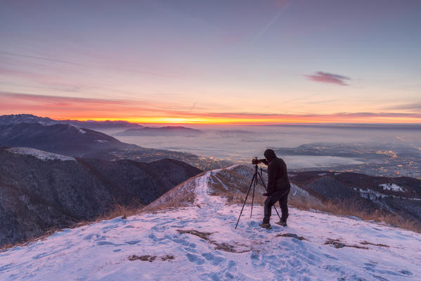 Photographer taking a picture on Bollettone Mount, Como province, Lombardy, Italy
