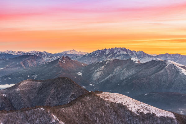 Overviewed of Resegone, Monte Rai and Cornizzolo peaks from Bollettone Mount and colourful sunrise sky in the background, Como province, Lombardy, Italy