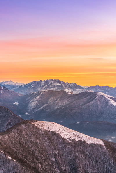 Overviewed of Resegone, Monte Rai and Cornizzolo peaks from Bollettone Mount and colourful sunrise sky in the background, Como province, Lombardy, Italy