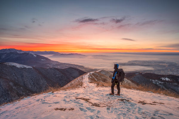 Young hiker admiring Brianza view from Bollettone Mount at sunrise, Como province, Lombardy, Italy (MR)