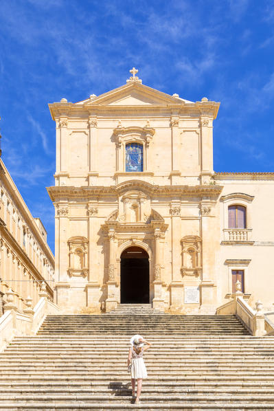 Young woman climbing the stairs of San Francesco all'Immacolata church, Noto, Siracusa province, Sicily, Italy