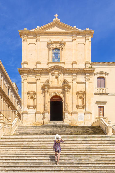 Young woman climbing the stairs of San Francesco all'Immacolata church, Noto, Siracusa province, Sicily, Italy (MR)