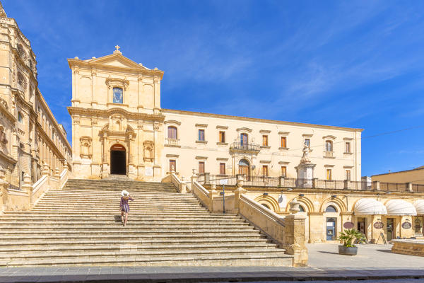 Young woman climbing the stairs of San Francesco all'Immacolata church, Noto, Siracusa province, Sicily, Italy