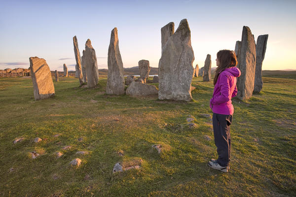 Woman staring at Neolithic stone circle, Callanish, Isle of Lewis, western scotland,United Kingdom