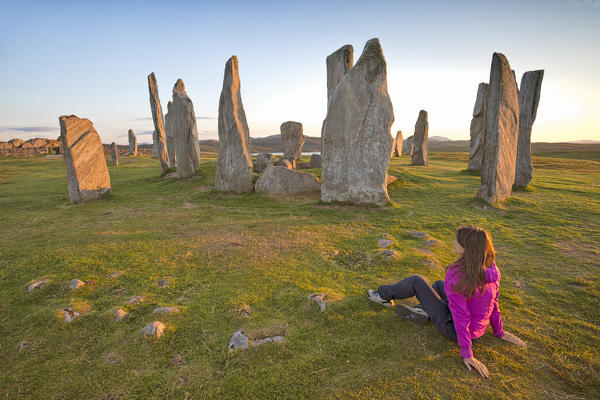 Woman staring at Neolithic stone circle, Callanish, Isle of Lewis, western scotland,United Kingdom