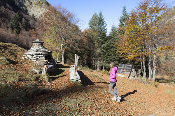 Woman staring at an ancient oven in Valle Loana, Verbano Cusio Ossola province, Piedmont, North italy, Italy