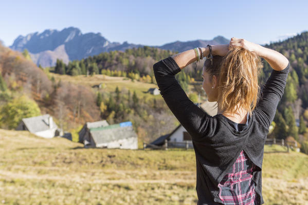 Model staring beautiful landscape of Alpe Blitz, in front of Monte Limidario, Craveggia, Val Vigezzo, Verbano Cusio Ossola province, Piedmont, North italy, Italy
