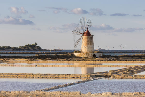 Salt pans with rows of tanks and a fully functional windmill on the coast connecting Marsala to Trapani, Trapani province,Sicily,Italy
