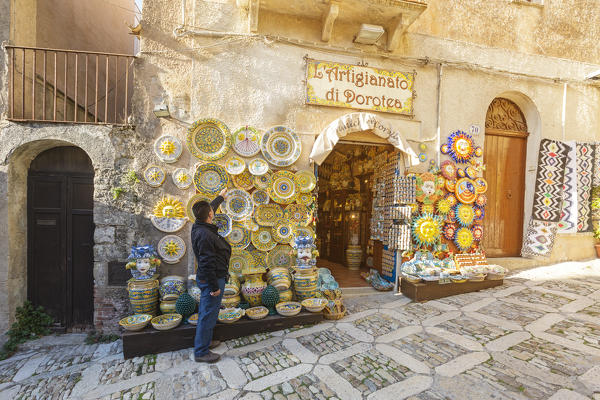 Man having a look at a pottery store in Erice, Trapani province, Sicily, Italy