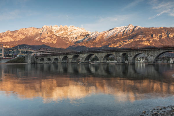 Reflection of the Lecco's old bridge and snow-covered Resegone, Lecco, Lecco province, Lombardy, Italy