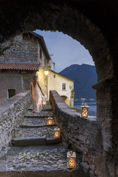 Woman walking along the bridge of the Civera with a lantern in the hand, Horrid of Nesso, Como province, Lombardia, Italy (MR)