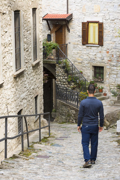 Man walking along a Steep street of Nesso, Nesso, Como province, Lombardia, Italy