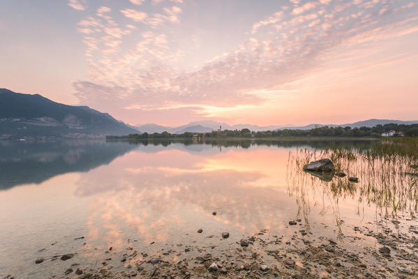 Clouds at sunrise reflected in the Pusiano lake viewed from Bosisio Parini lakefront, Lecco province, Lombardy, italy