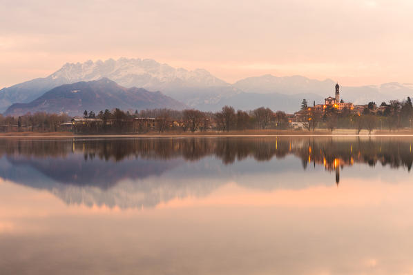 San Giuseppe Church and Bosisio Parini lakefront reflected in the Pusiano lake with Resegone mount in the background, Lecco province, Lombardy, italy