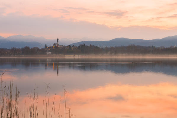 San Giuseppe Church and Bosisio Parini lakefront reflected in the Pusiano lake at sunrise, Lecco province, Lombardy, italy