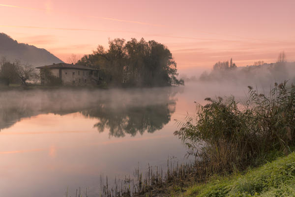 Reflections on Adda river at a foggy dawn, Lecco Province, Lombardy, Italy