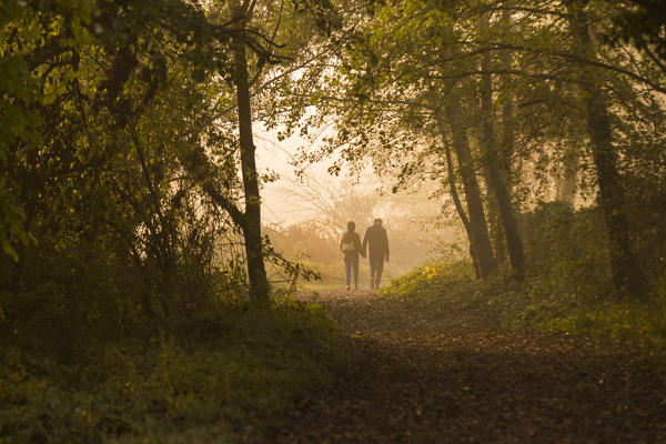 People walking along Adda riverside at sunrise, Lecco, lecco province, Lombardy, italy