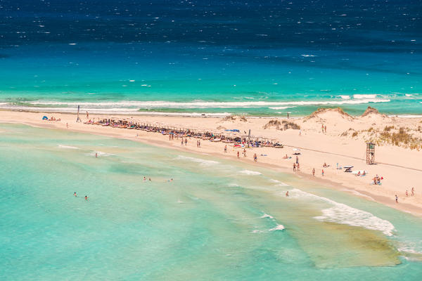 People on the narrow stretch of white sand which divides Simos beach, Elafonissos, Laconia Region, Peloponnese, Greece