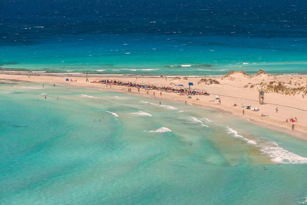 People on the narrow stretch of white sand which divides Simos beach, Elafonissos, Laconia Region, Peloponnese, Greece