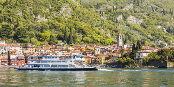A touristic ferry crossing Lake Como with the village of Varenna in the background, Lecco province, Lombardy, italy