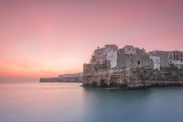 Old town of Polignano a Mare built on rocky cliffs at sunrise, Bari province, Apulia region, Italy