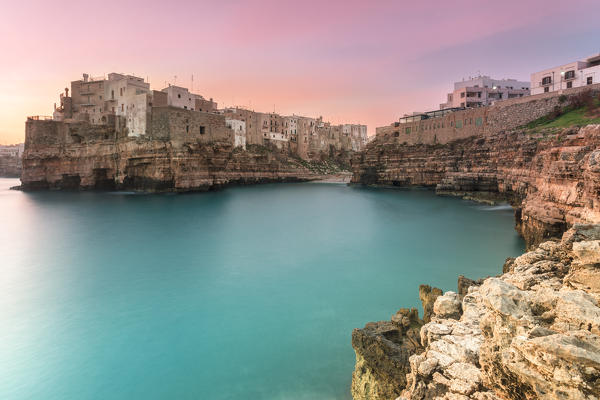 Old town of Polignano a Mare built on rocky cliffs at sunrise, Bari province, Apulia region, Italy