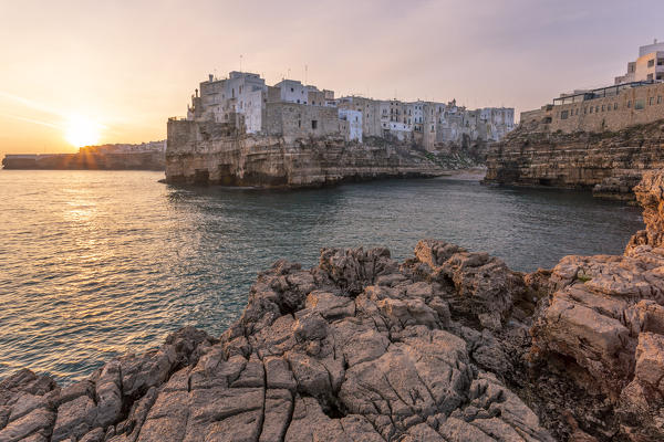 Old town of Polignano a Mare built on rocky cliffs at sunrise, Bari province, Apulia region, Italy