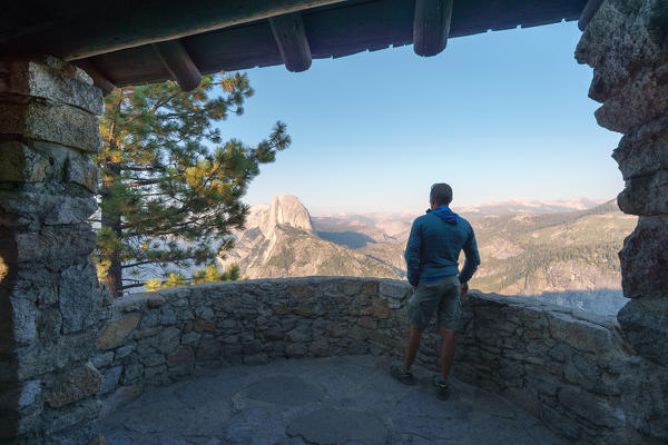 Tourist admiring Half Dome and Yosemite Valley from the trailside museum at Glacier Point, Yosemite National Park, California, Sierra Nevada, North America, USA (MR)