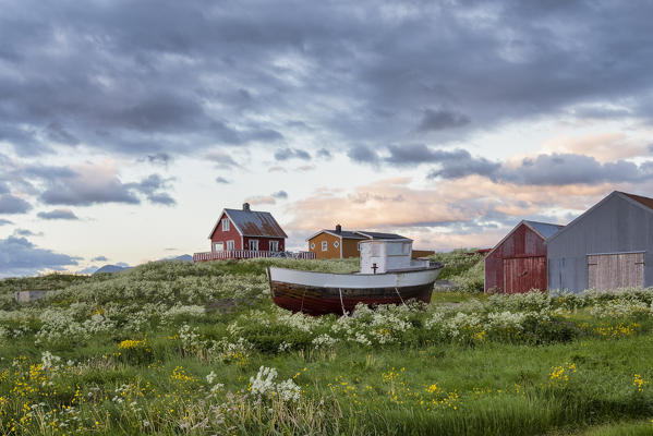 Little fishing boat in the meadow in front of typical houses, Eggum, Unstad, Vestvagøy, Lofoten Islands, Norway, Europe