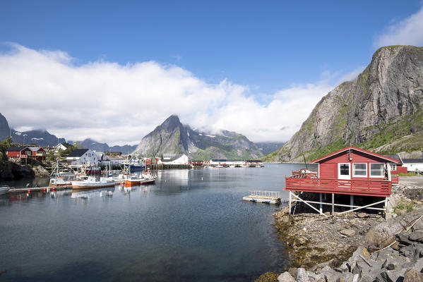 Typical house of fishermen and peaks of Hamnøy, Moskenes, Nordland county, Lofoten Islands, Northern Norway, Europe