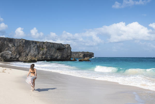 Woman with pareo walks on the beach of Bottom Bay, Barbados Island, Lesser Antilles, West Indies, Caribbean region